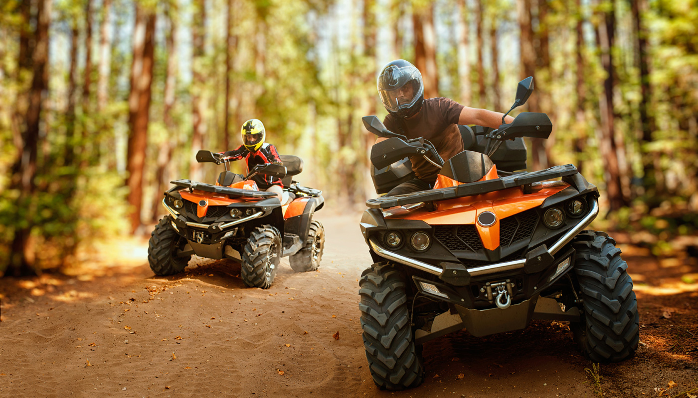 Two atv riders speed race in forest